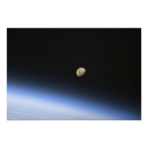 A gibbous moon visible above Earth's atmosphere