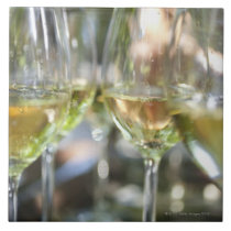 A host pours glasses of torrontes for guests at tile