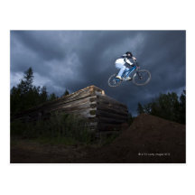 A mountain biker jumps off a log cabin in Idaho. Post Card