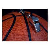 A referee's whistle rests on top of a greeting card