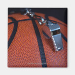 A referee's whistle rests on top of a fridge magnet