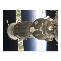 A Soyuz spacecraft backdropped by Earth Photograph