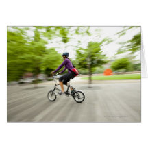 A woman using a folding bike to commute card