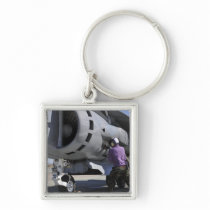 Aviation fuel technician attaches a fuel line keychain