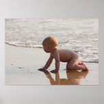 Baby playing in the sand on the beach posters