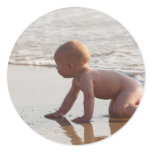 Baby playing in the sand on the beach stickers