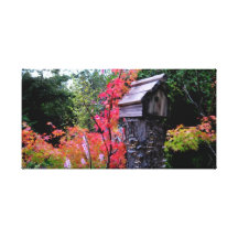 Birdhouse on Tree Stump Nestled in Leaves Stretched Canvas Print