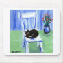 Black cat naps on chair mouse pad