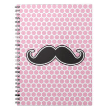 Black handlebar moustache on pink polka dot patter notebook