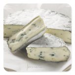Blue cheese with pieces cut on paper square stickers