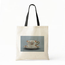Cup and saucer with colourful flowers on it. bags