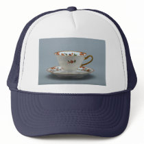 Cup and saucer with colourful flowers on it. mesh hats
