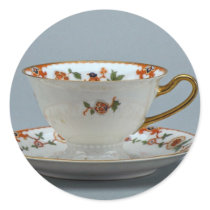 Cup and saucer with colourful flowers on it. round stickers