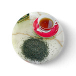 Cup of black tea with tea leaves buttons