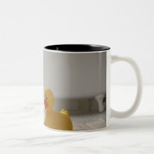 Dog on mat with plastic duck coffee mug