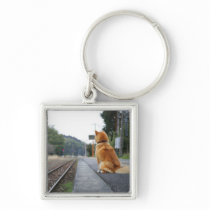 Dog sitting on train station key chain