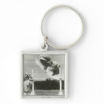 Dogs jumping over miniature high jump bar keychains
