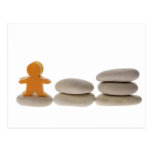 Figurine on stack of pebbles postcard