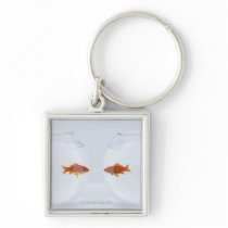 Goldfish in separate fishbowls looking face to key chain