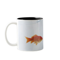Goldfish in separate fishbowls looking face to coffee mug