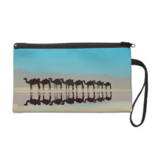 Group of camels walking in desert wristlet purses