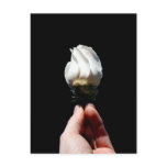 Hand holding white rose bud black background post card