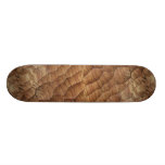Lines carved in pale brown wood skate board deck