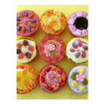 Nine cupcakes each decorated with candy in a post cards