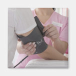 Nurse taking patient's blood pressure fridge magnet