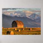 Old barn framed by hay bales and dramatic