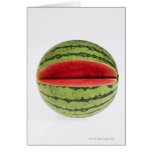 Organic watermelon with a slice cut into it, on card