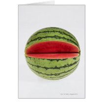 Organic watermelon with a slice cut into it, on card