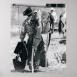 Rear view of cowboy hauling gear posters