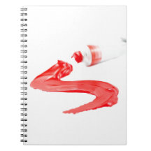 red oil paints squeezed out from tube spiral notebook