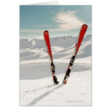 Red pair of ski standing in snow greeting card