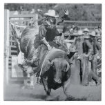 Rider hanging on to bucking bull ceramic tile