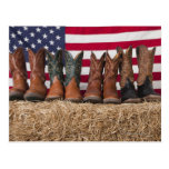 Row of cowboy boots on haystack postcard