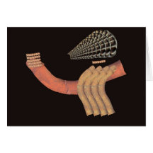 Scrap metal horn head figure seated on pipe cards