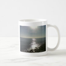 the sun rising over the sea coffee mugs