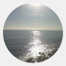 the sun rising over the sea round stickers