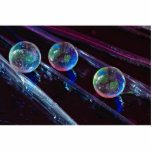 Three glass marbles rolling on smooth surface photo sculptures