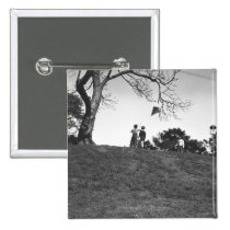 Two boys flying kite on hill B&W buttons
