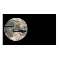 two helicopters silhouetted by a full moon