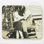 Two lovers kissing on a bench mousepads
