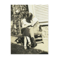 Two lovers kissing on a bench postcard
