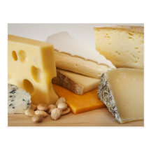 Various cheeses on chopping board post card