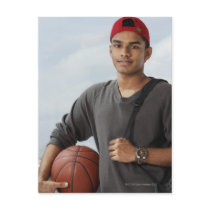 young man with red cap holding basket ball and post card