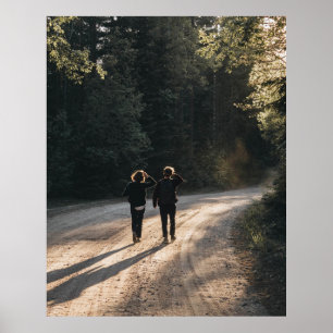 2 women walking on road between trees in the morni poster