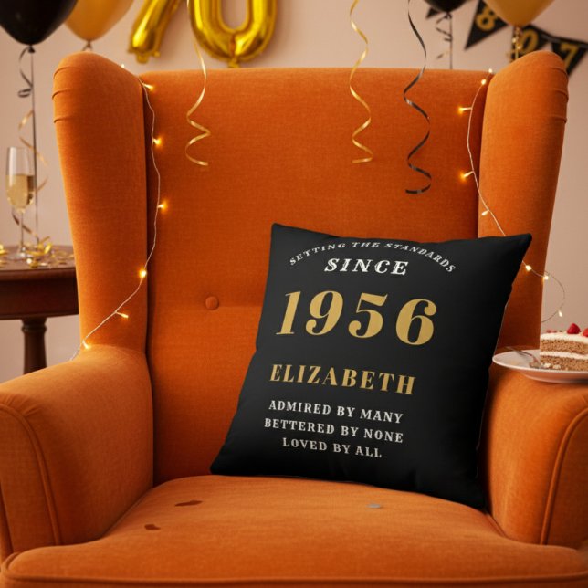 70th Birthday Gift Personalized 1956 Black Gold Cushion (Personalized 70th birthday throw pillow on an orange velvet wingback chair)
