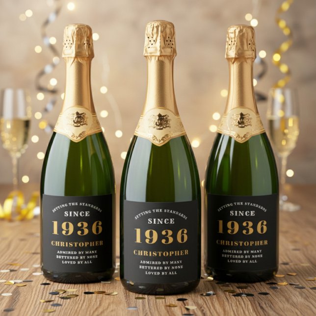 90th Birthday Born 1936 Add Name Black Gold Sparkling Wine Label (Born 1936 sparkling wine bottle labels. Background out of focus.)